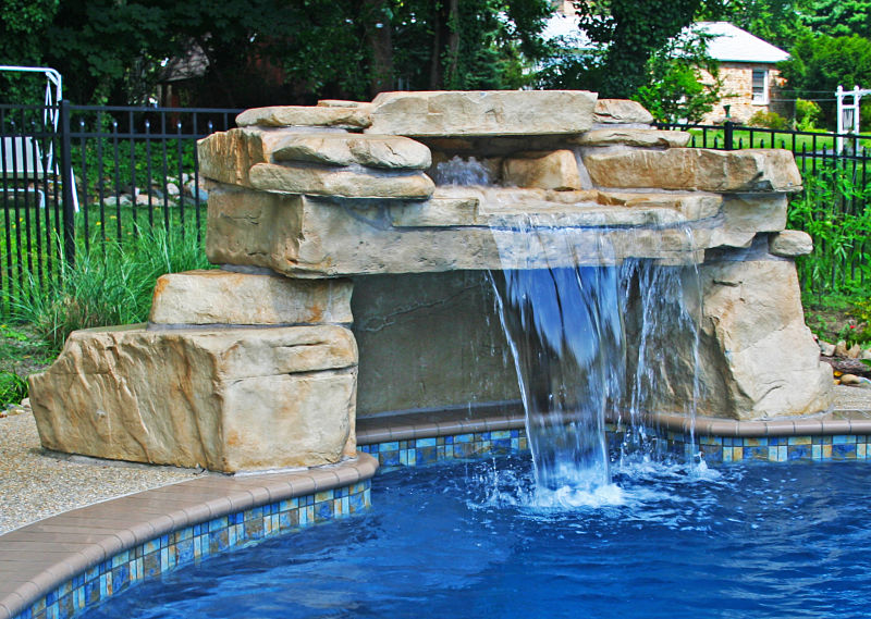 piscina con cueva de roca artificial y cascada artificial 